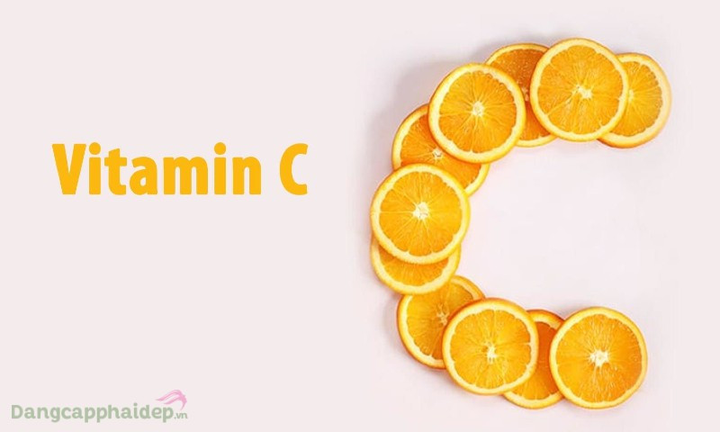 alt text: Hũ kem dưỡng vitamin C mở nắp, bên cạnh là vài lát cam tươi